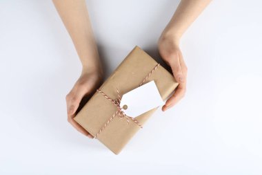 Beyaz arkaplanda etiketli bir pakete sarılı kadın, üst görünüm