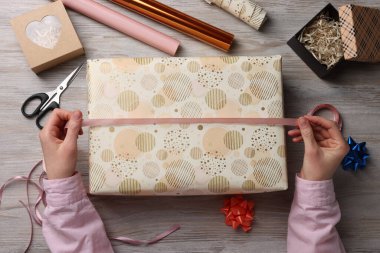 Beyaz ahşap masada Noel hediyesi sarma kadın, üst görünümü