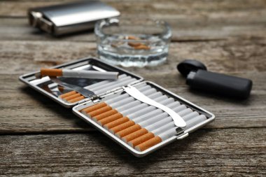 Tütün filtresi, sigara, çakmak ve kül tablası ile ahşap masa, yakın plan