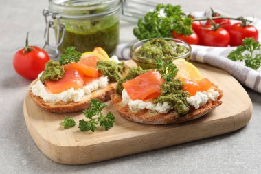 Somon, krem peynir ve açık gri masada pesto soslu nefis bruschettalar.