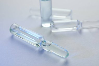 Beyaz arka planda ilaçlı ilaç ampulleri, yakın plan.