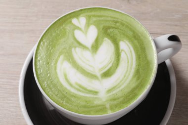 Masada bir fincan taze kibrit latte, yakın plan.