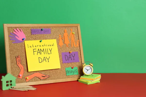 国际家庭日快乐 用软木塞 卡片和文具在红色桌子上与绿色背景相对照的构图 文字空间 — 图库照片