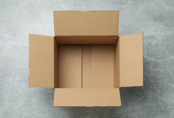 Empty Open Cardboard Box Grey Table Top View — Zdjęcie stockowe