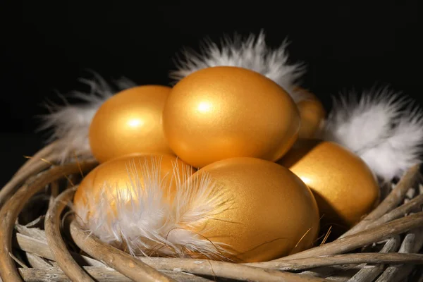 Glanzende Gouden Eieren Met Veren Nest Zwarte Achtergrond Close — Stockfoto