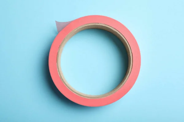 Roll Pink Adhesive Tape Light Blue Background Top View — Zdjęcie stockowe