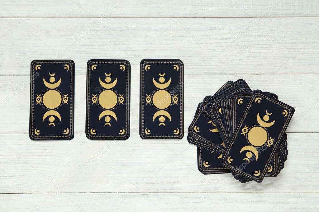Tarot cards on white wooden table, flat lay. Reverse side