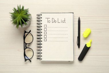 Düz kompozisyon ve doldurulmamış yapılacaklar listesi tahta masanın üzerinde.