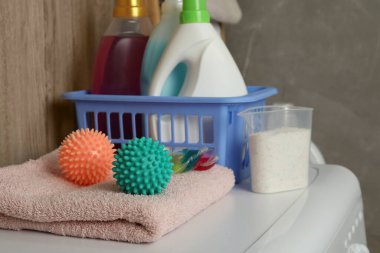 Çamaşır makinesinde kurutucu topları, deterjanlar ve temiz havlu.