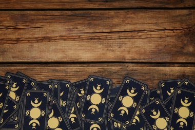 Tarot cards on wooden table, top view and space for text. Reverse side clipart