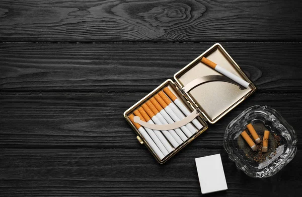 Cigarettes Case Matchbox Ashtray Stubs Black Wooden Table Flat Lay — Zdjęcie stockowe