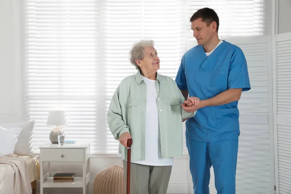 Caregiver Assisting Senior Woman Walking Cane Indoors Home Health Care — 스톡 사진