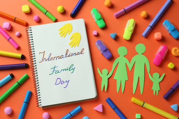 国际家庭日快乐 用笔记本和纸在橙色背景下裁剪的平面写作方法 — 图库照片