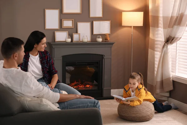 快乐的家人一起在家里壁炉边看书 — 图库照片