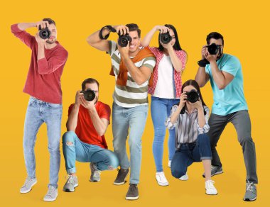 Turuncu arka planda kameraları olan bir grup profesyonel fotoğrafçı