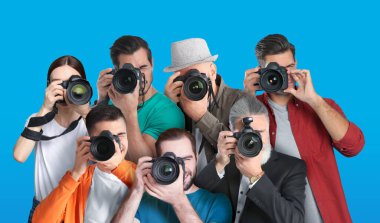 Turkuaz arka planda kameraları olan bir grup profesyonel fotoğrafçı