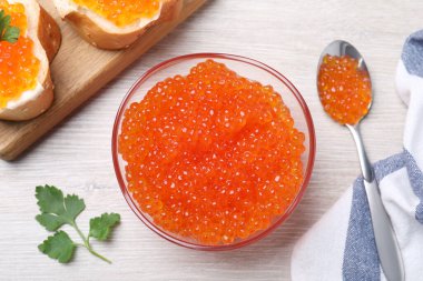Lezzetli kırmızı havyarla bembeyaz ahşap masa üzerinde düz kompozisyon