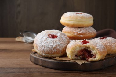 Lezzetli çörekler ve pudra şekeri ahşap masada.