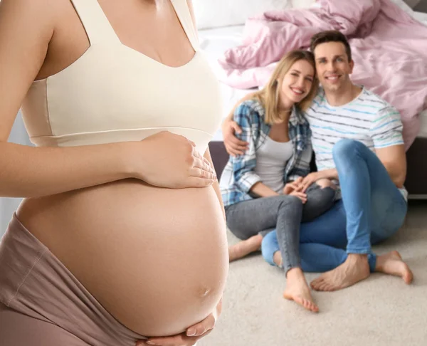 代理出産の概念 若いです妊娠中の女性とぼやけたビューの幸せなカップル屋内 — ストック写真