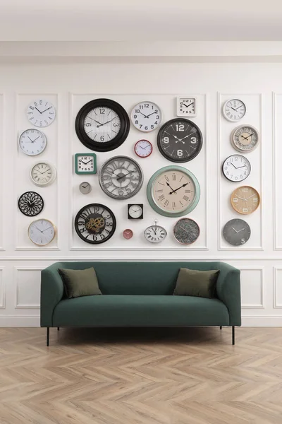 Coleção Diferentes Relógios Sofá Confortável Quarto Elegante Design Interiores — Fotografia de Stock