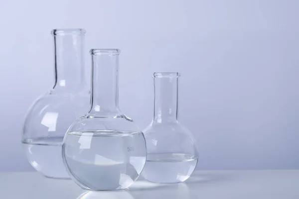 Florence Flasks Transparent Liquid Table Light Background Space Text — стоковое фото