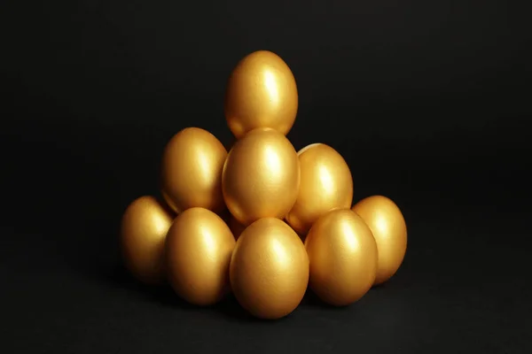Pile Shiny Golden Eggs Black Background — Zdjęcie stockowe