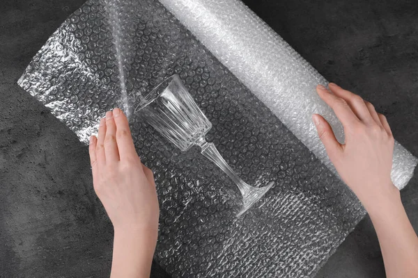 Woman Covering Wineglass Bubble Wrap Dark Grey Table Closeup — Zdjęcie stockowe
