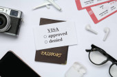 Composition with passport, toy plane and tickets on white background, top view. Visa receiving