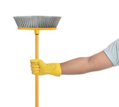 Beyaz arka planda sarı süpürgesi olan genç adam, yakın plan.