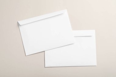 Beyaz kağıt zarflar bej arka planda, düz yatıyordu