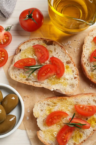 Sabrosos Bruschettas Con Aceite Tomates Romero Sobre Papel Pergamino Aplanado —  Fotos de Stock