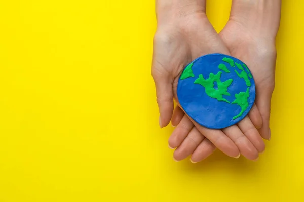Woman Holding Plasticine Model Planet Yellow Background Top View Space — Stock Fotó
