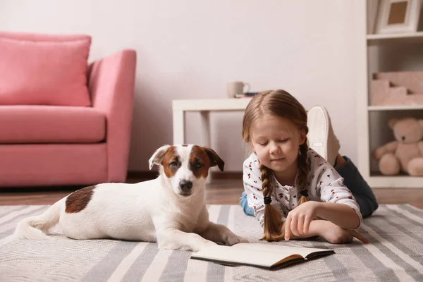 Menina Bonito Com Seu Cão Lendo Livro Sobre Tapete Casa — Fotografia de Stock