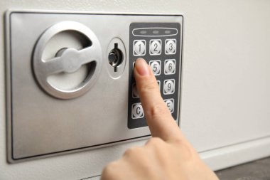 Çelik kasayı elektronik kilitle açan kadın, yakın plan.