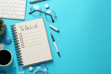 Düz kompozisyon, doldurulmamış yapılacaklar listesi ve açık mavi arka planda bir fincan kahve, metin için boşluk