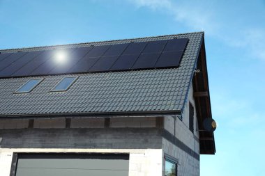 Çatıda güneş panelleri olan bir ev. Alternatif enerji