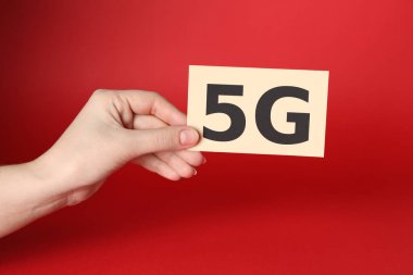 İnternet konsepti. Kırmızı arkaplanda 5G kartı olan kadın, yakın plan.