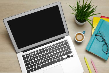 Modern dizüstü bilgisayar, bir fincan kahve ve ahşap masa üzerinde ofis kırtasiyesi, düz yatak. Uzaklık öğrenimi