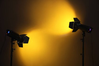 Karanlık odadaki duvarın yanındaki parlak spot ışıkları, metin için boşluk