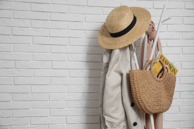 Koridordaki beyaz tuğla duvarın yanında giysi ve aksesuar rafı, mesaj için yer. İç öge