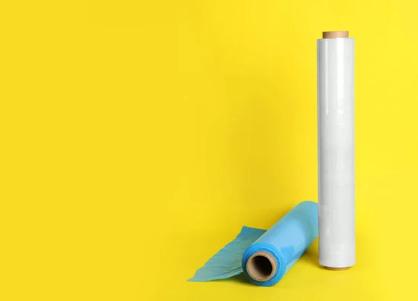 Rolls of different stretch wrap on yellow background. Space for text