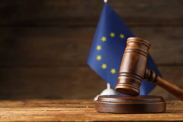 Judge's gavel and European Union flag on wooden table. Space for text