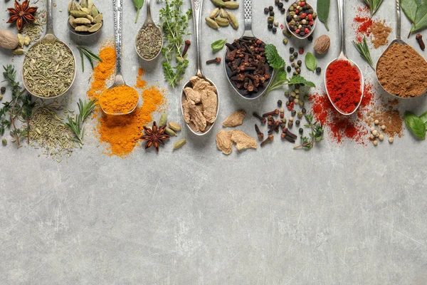 Different Herbs Spices Spoons Grey Table Flat Lay Space Text — стоковое фото