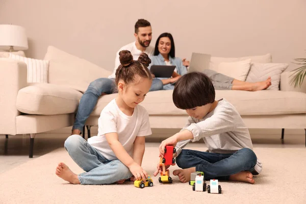 Cute Children Playing Toys While Parents Using Gadgets Sofa Living — Stock Photo, Image