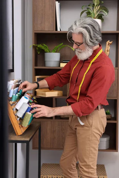 Atölyenin yanında iplik seçen profesyonel bir terzi