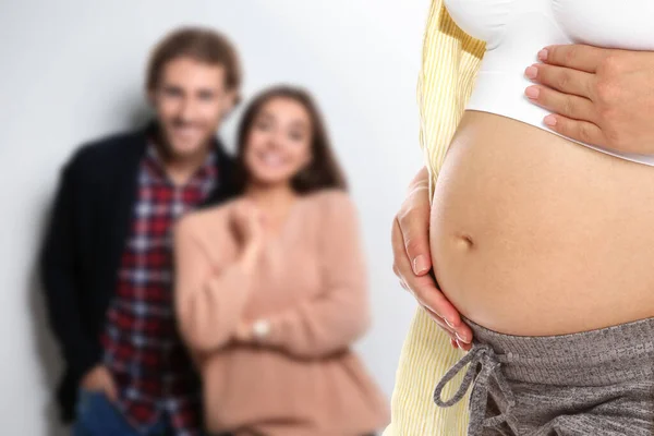 代理出産の概念 若いです妊娠中の女性とぼやけたビューの幸せなカップル上の光の背景 — ストック写真