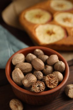 Nutmeg tohumları ve ahşap masada lezzetli elmalı turta.