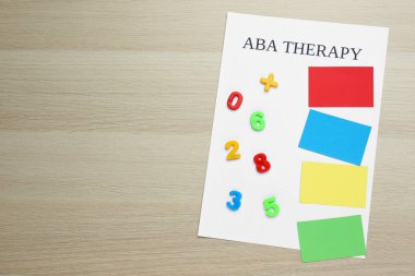 ABA terapisi ve beyaz ahşap masa üzerinde rakamlar olan farklı renkler. Metin için boşluk