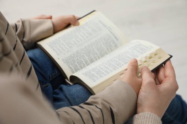 Oğlan ve vaftiz ebeveyni birlikte İncil okuyor, yakın plan.