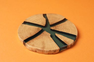 Turuncu arka planda şık bir bardak altlığı, yakın plan.